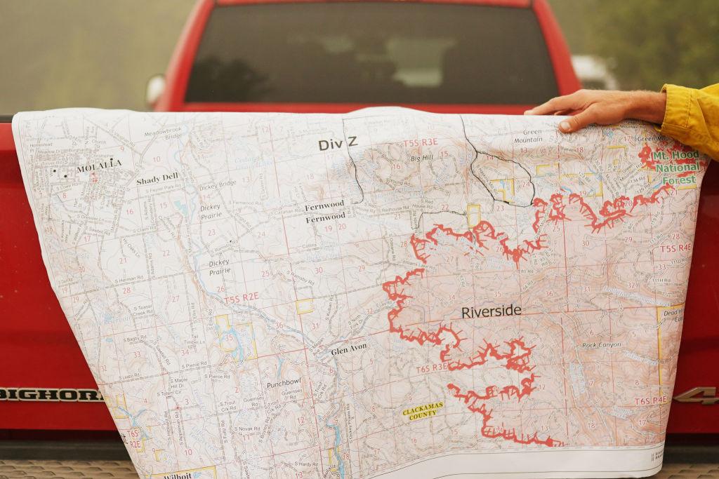 A firefighter displays a map of the Riverside Fire in Glen Avon, Ore., on Sept.13, 2020 (Nathan Howard/Getty Images)