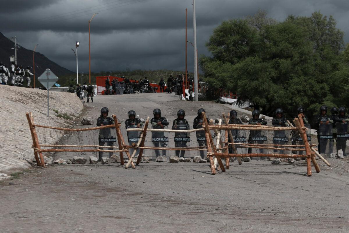  National Guard troops equipped with riot gear stand guard at Las Pilas dam, two days after withdrawing from nearby La Boquilla dam after clashing with hundreds of farmers, in Camargo, Chihuahua State, Mexico, on Sept. 10, 2020. (Christian Chavez/AP Photo)