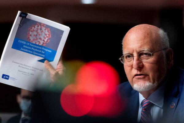 CDC Director Dr. Robert Redfield holds up a CDC document as he speaks during a Senate Appropriations Subcommittee hearing "Review of Coronavirus Response Efforts" on Capitol Hill, Washington, Sept. 16, 2020. (Andrew Harnik/Pool via Reuters)