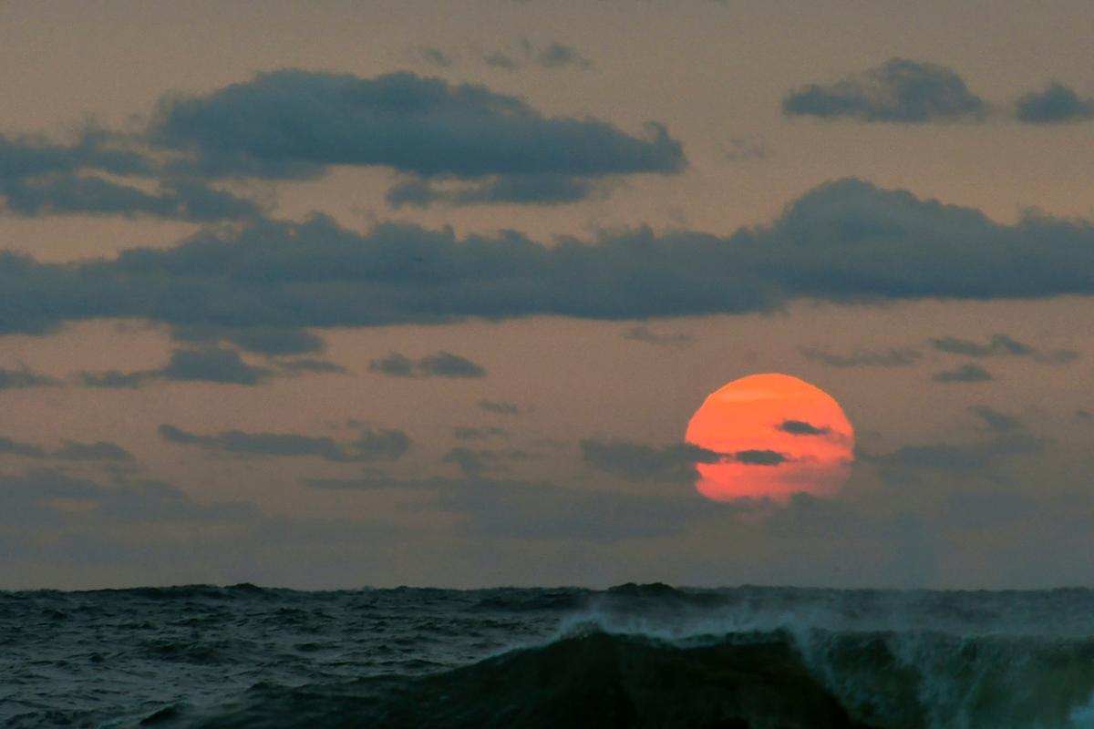 This photo taken at sunrise from Surf City on Long Beach Island in New Jersey shows the sun shrouded in smoke and brown haze Tuesday, Sept. 15, 2020. (Elizabeth Laird via AP)