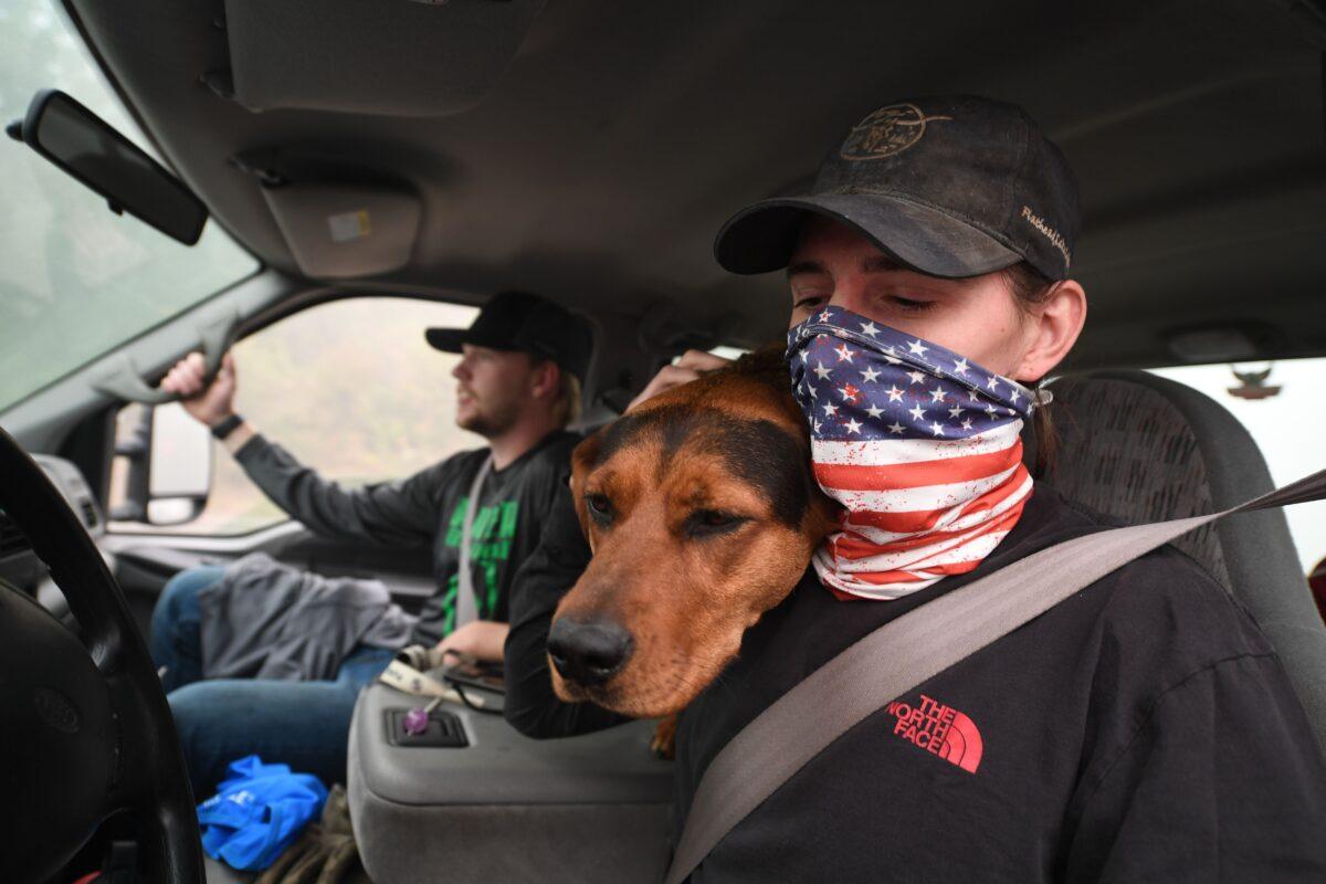 James Smith hugs his dog Rose after returning to his evacuated home to find looters had stolen his motorcycles, in Estacada, Ore., Sept. 12, 2020. (Robyn Beck/AFP via Getty Images)