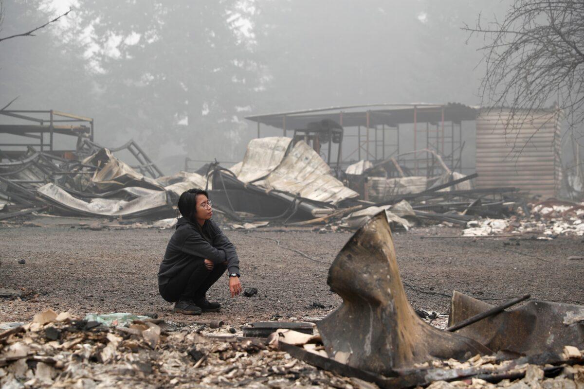 Hansel Valentine, 24, inspects the remains of the burnt down property of her relatives, as the wildfire continues in Estacada, Ore., Sept. 13, 2020. (Shannon Stapleton/Reuters)
