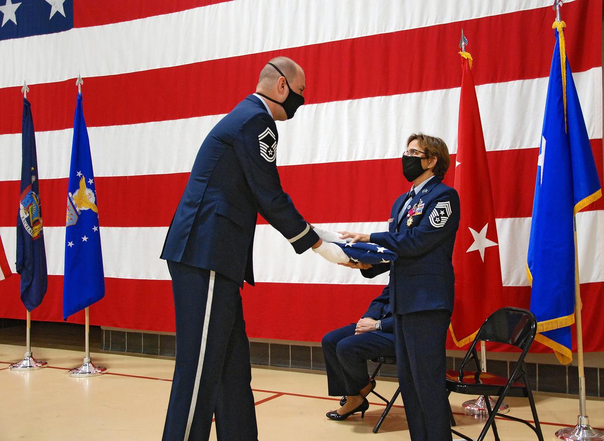 Dooley receives her retirement flag from Senior Master Sgt. Tom Whiteman on Sept. 18, 2020. (<a href="https://www.dvidshub.net/image/6355827/command-chief-master-sgt-maureen-dooley-retirement">William Albrecht</a>/New York State Division of Military and Naval Affairs)