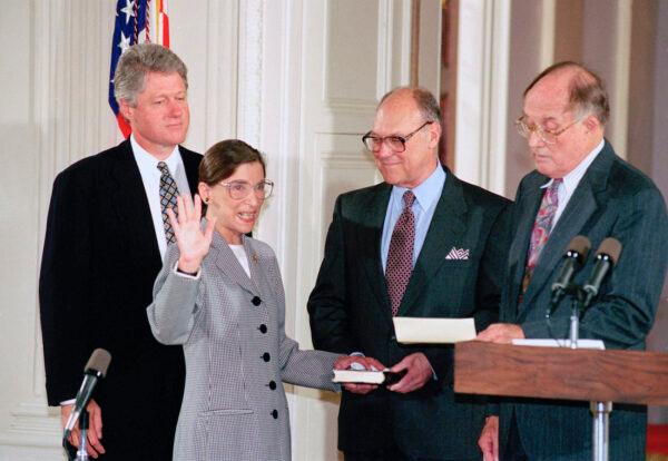Supreme Court Justice Ruth Bader Ginsburg takes the court oath from Chief Justice William Rehnquist (R), as Ginsburg's husband Martin holds the Bible and President Bill Clinton watches (L), during a ceremony in the East Room of the White House in Washington on Aug. 10, 1993. (Marcy Nighswander, File/AP Photo)