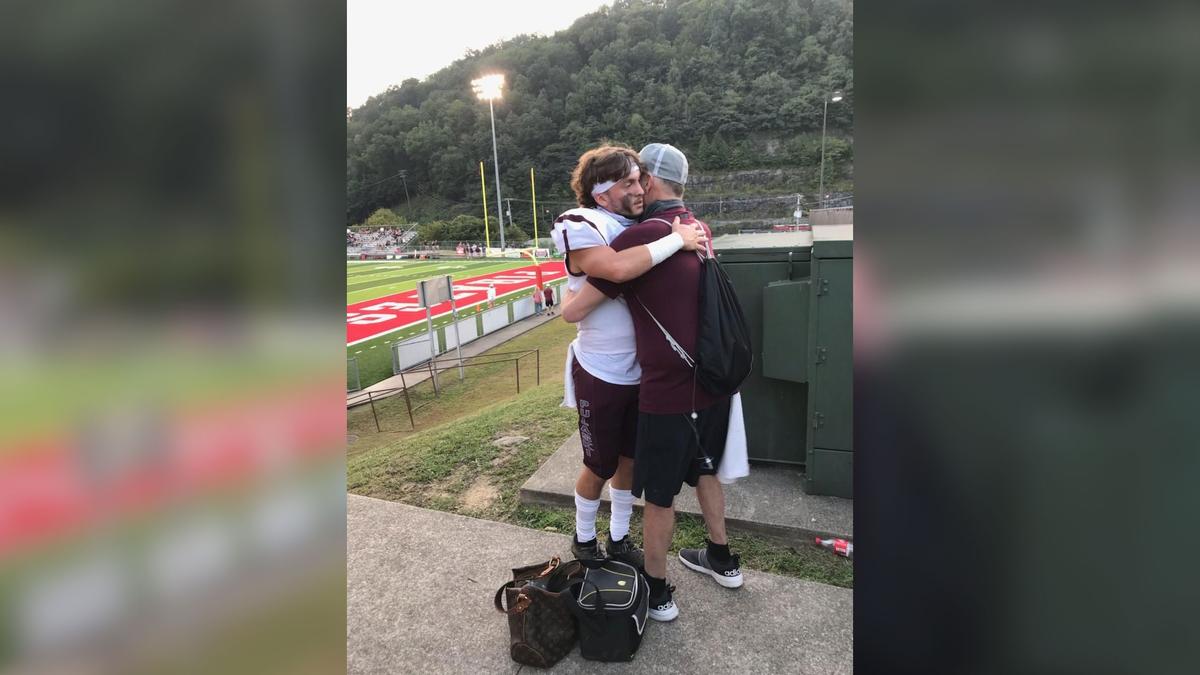 Scott Sullivan, terminally ill with cancer, hugs his son Cade before the opening game of high school football season. (Courtesy of Jerree Humphrey)