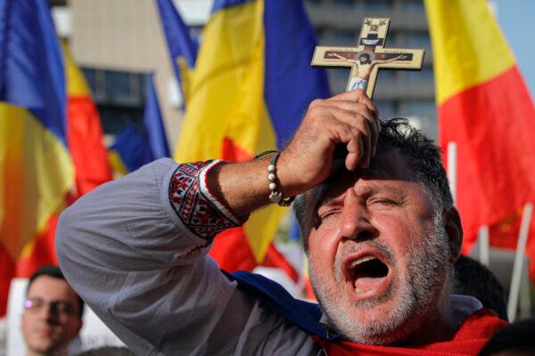 A man shouts slogan against the use of face masks as a means of protection against the COVID-19 infection during a protest in Bucharest, on Sept. 19, 2020. (Vadim Ghirda/AP Photo)