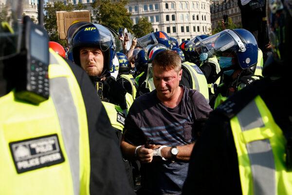 A man is detained during a demonstration in Trafalgar Square against the lockdown imposed by the government, in London, on Sept. 19, 2020. (Henry Nicholls/Reuters)
