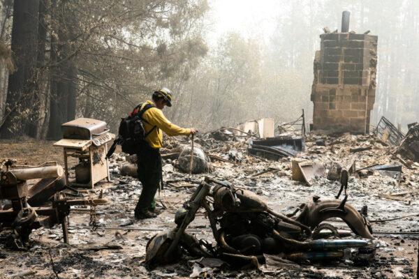 A firefighter works through the remains of a burned-out house in Estacada, Ore., on Sept. 14, 2020. (Nathan Howard/Getty Images)