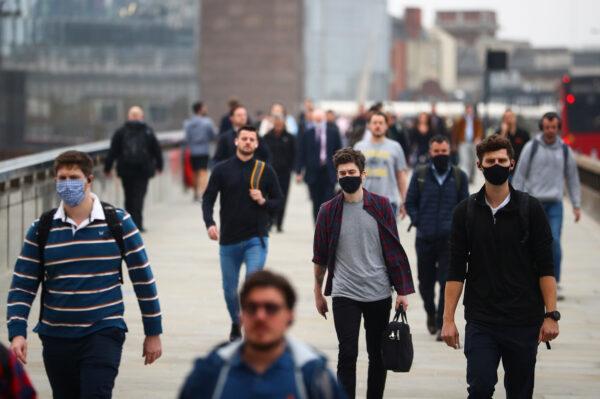 Commuters walk across London Bridge during the morning rush hour amid an outbreak of the CCP virus in London on Sept. 21, 2020. (Reuters/Hannah McKay)