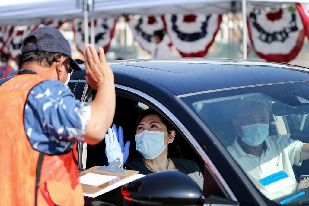 A woman is sworn in as a new U.S. citizen from inside a vehicle at a drive-in naturalization ceremony in Santa Ana, Calif., on July 29, 2020. (Mario Tama/Getty Images)