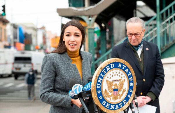 Rep. Alexandria Ocasio-Cortez (D-N.Y.) speaks as Senate Minority Leader Chuck Schumer (D-N.Y.) listens during a press conference in the Corona neighborhood of Queens in New York City, on April 14, 2020. (Johannes Eisele/AFP via Getty Images)