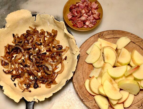 Layer the filling into the crust: browned onions, apple, and bacon. (Cardinale Montano)