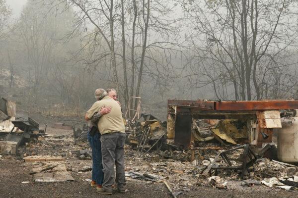 Larry Weyand (L) hugs Darwin Seim in front of Weyand's burned mobile home at the Clackamas River RV Park in Estacada, Ore., on Sept. 14, 2020. Multiple wildfires continued to burn in Oregon as thousands remained evacuated across the West. (Nathan Howard/Getty Images)