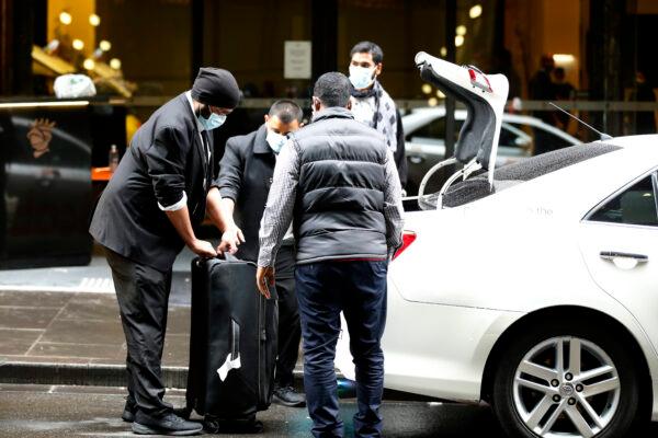Guests at the Stamford Hotel in Melbourne, Australia are seen wearing masks as they get into taxis on June 25, 2020. (Photo by Darrian Traynor/Getty Images)