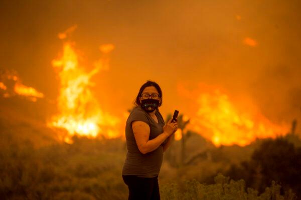 A woman watches as the Bobcat Fire burns in Juniper Hill, Calif., on Sept. 18, 2020. (Ringo H.W. Chiu/AP Photo)