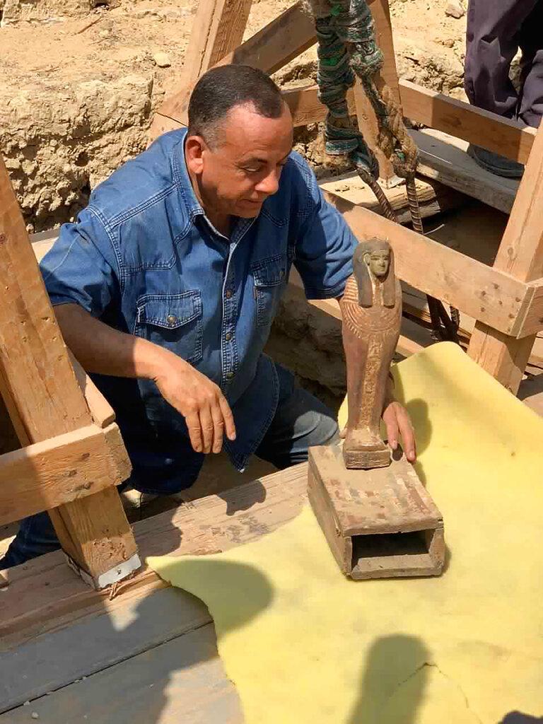 Mostafa Waziri, secretary-general of the Supreme Council of Antiquities, with an artifact found along with more than two dozen ancient coffins unearthed near the famed Step Pyramid of Djoser in Saqqara, south of Cairo, Egypt. (Ministry of Tourism and Antiquities via AP)