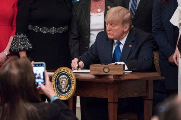 President Donald Trump signs an executive order to create a new position for the Domestic Policy Council during the White House Summit on Human Trafficking in Washington, on Jan. 31, 2020. (Sarah Silbiger/Getty Images)