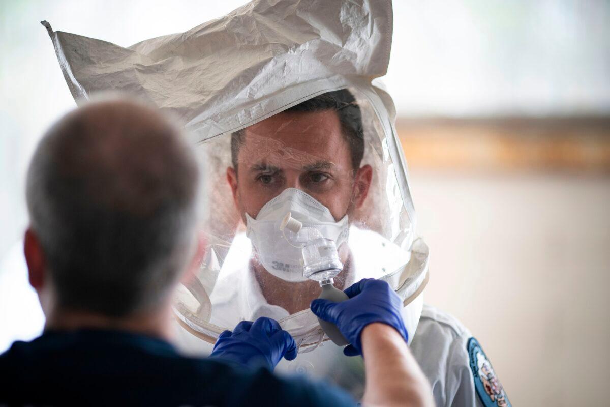 A paramedic with Anne Arundel County Fire Department tests his N-95 mask at the start of his 24-hour shift in Glen Burnie, Md., on April 9, 2020. (Alex Edelman/AFP via Getty Images)