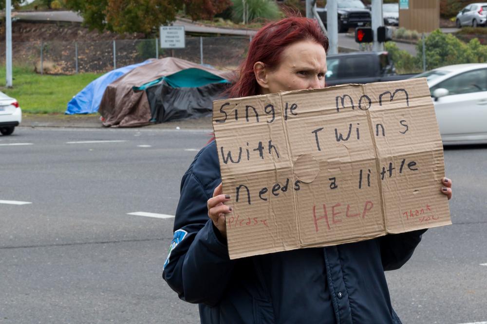 Homeless woman asking for help on urban intersection in Portland, Ore. (Victoria Ditkovsky/Shutterstock)