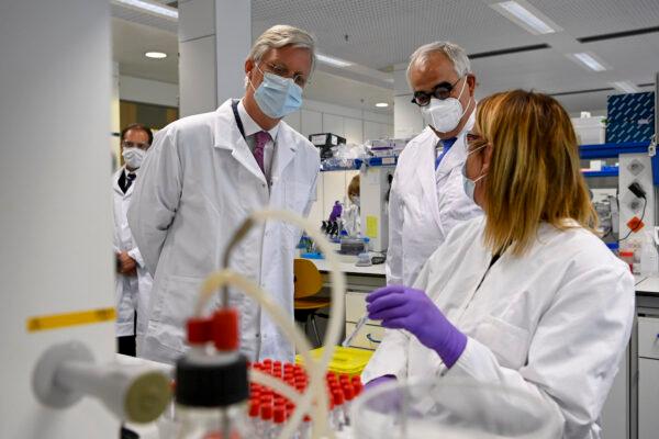 King Philippe of Belgium (L) and Janssen Pharmaceutica chief scientific officer Paul Stoffels (C) talk to a scientist at work in the laboratroy during a royal visit to the headquarters of Janssen Pharmaceutica in Beerse, Belgium, on June 17, 2020. (Dirk Waem/BELGA MAG/AFP via Getty Images)