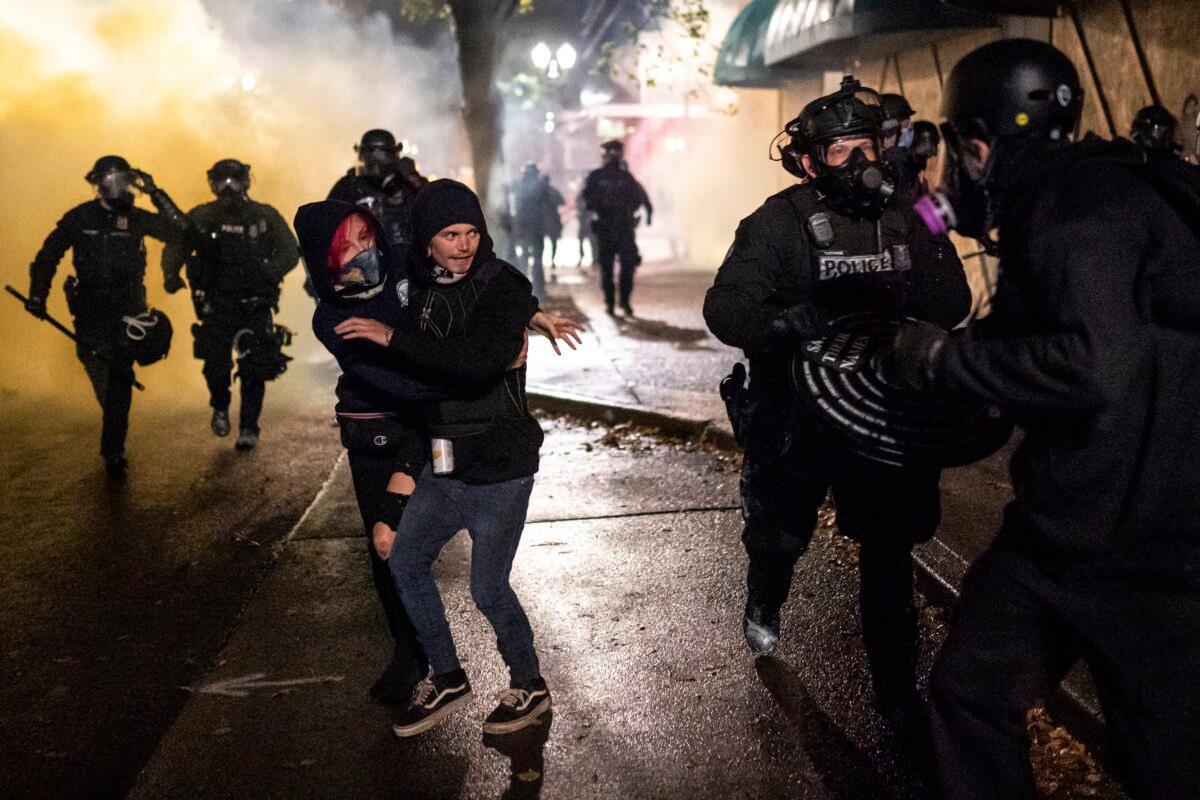 People move away from police officers amid rioting in Portland, Ore., Sept. 23, 2020. (Nathan Howard/Getty Images)