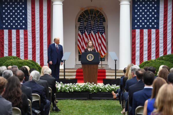 Judge Amy Coney Barrett, at podium, speaks, as President Donald Trump, center left, listens, following his nomination of the judge to the Supreme Court, in the Rose Garden at the White House in Washington on Sept. 26, 2020. (Olivier Douliery/AFP via Getty Images)