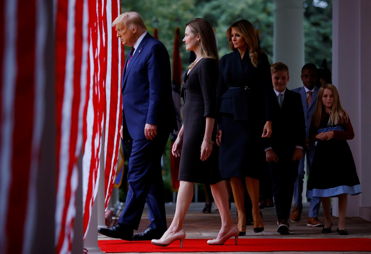 President Donald Trump, left, Judge Amy Coney Barrett, second from left, first lady Melania Trump, center, and Barrett's family walk to the Rose Garden at the White House in Washington on Sept. 26, 2020. (Carlos Barria/Reuters)