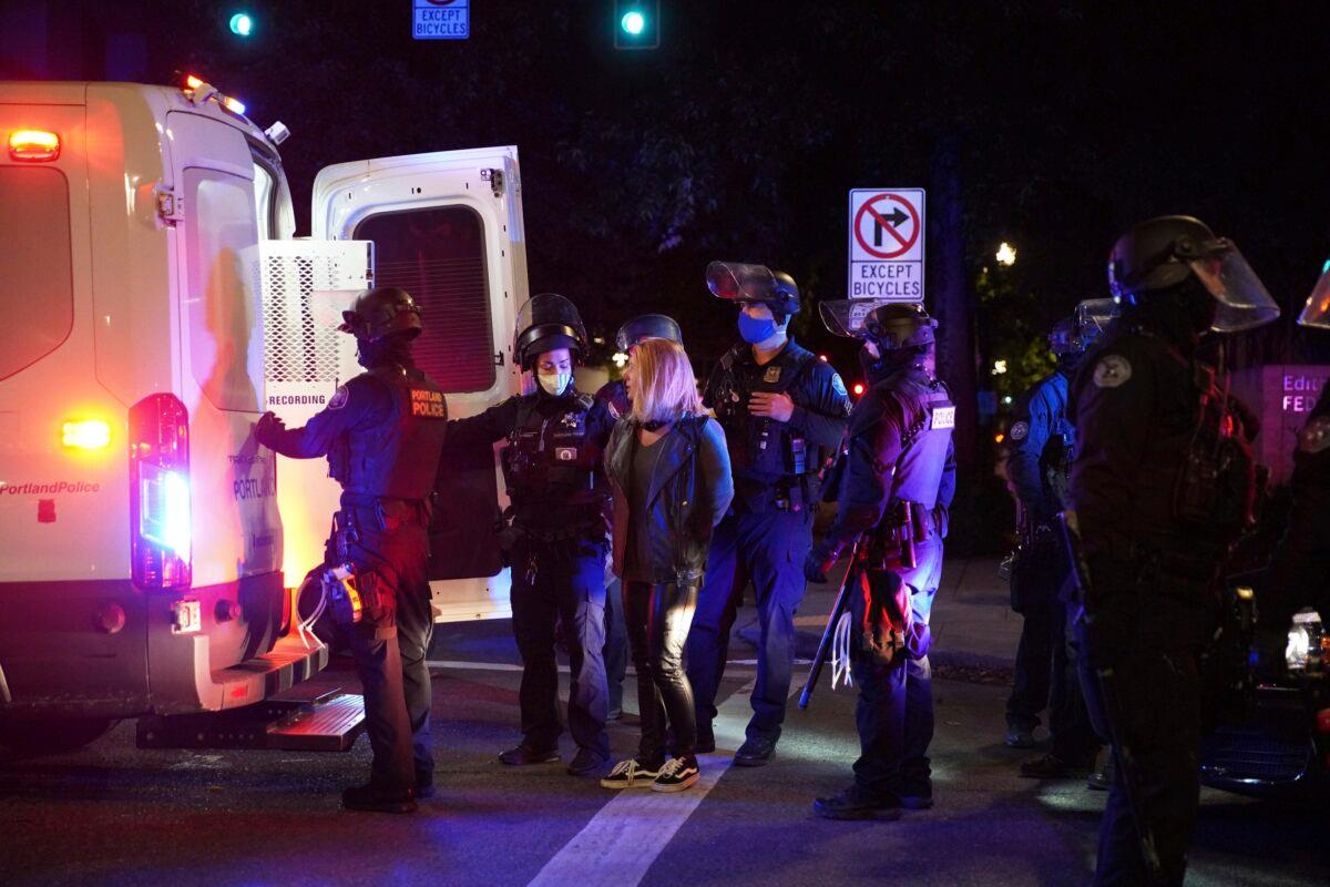 A female protester is loaded into a van after being arrested while rallying near the Mark O. Hatfield Courthouse in Portland, Ore., on Sept. 26, 2020. (Allison Dinner/AP Photo)