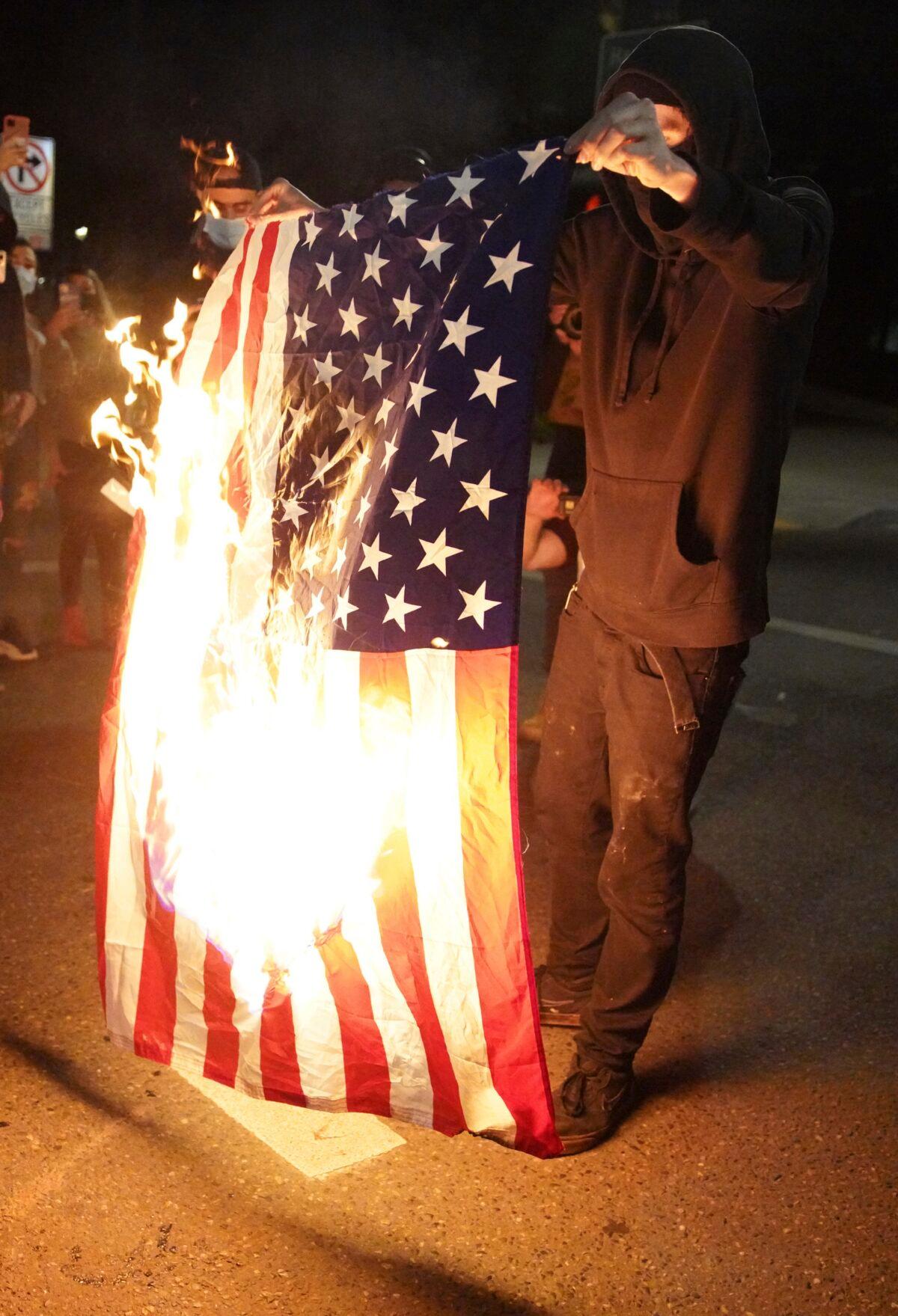 A protester burns an American flag while rallying in downtown Portland, Ore., on Sept. 26, 2020. (Allison Dinner/AP Photo)