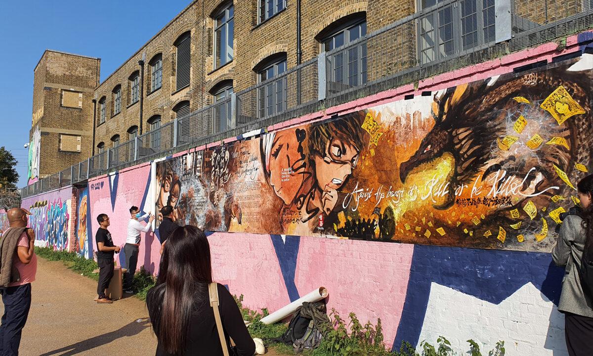 Otto Yuen, known in Hong Kong as The Lennon wall painter (4th left), sets up a display of his painting with the help of his friends, in London, on Sept. 20, 2020. (Lily Zhou/The Epoch Times)