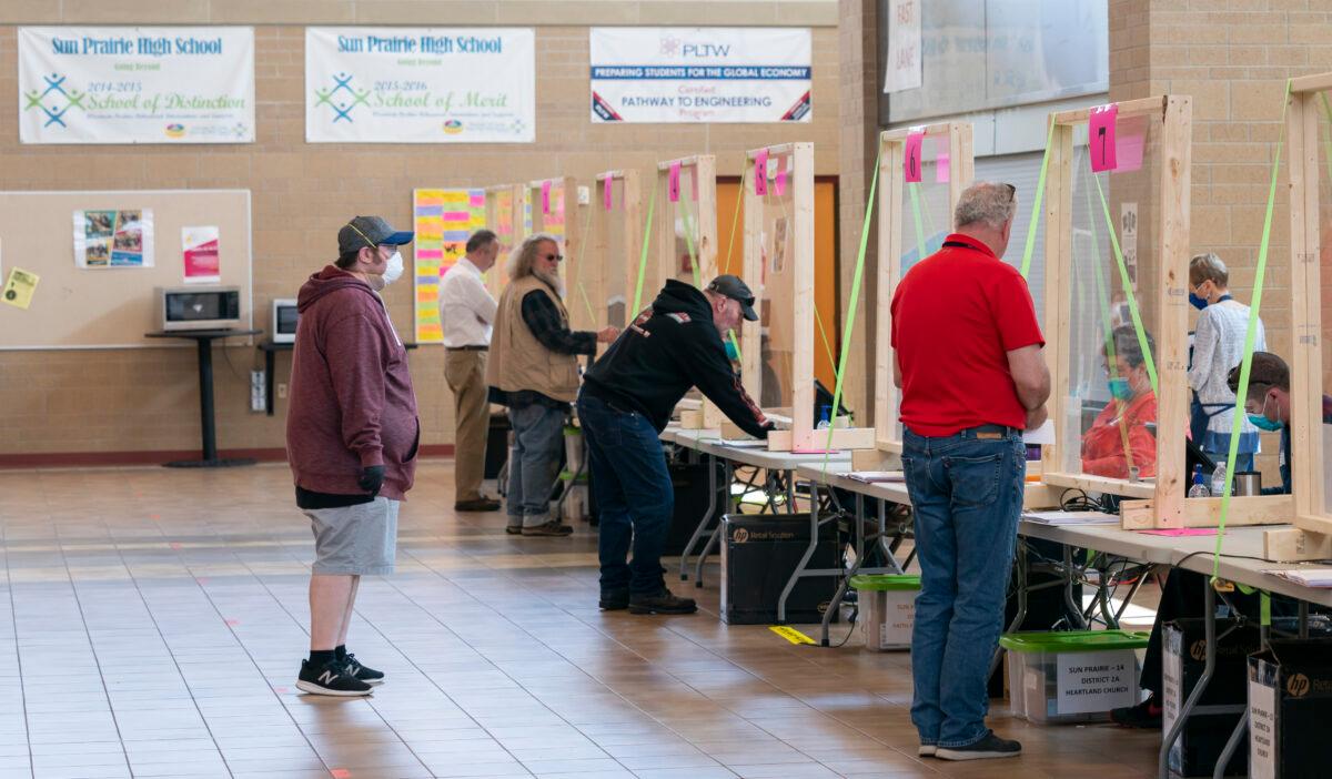 People check in to vote at a polling location in Sun Prairie, Wis., on April 7, 2020. (Andy Manis/Getty Images)