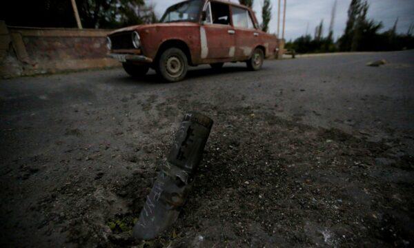 A car drives past the remains of spent ammunition following a recent shelling, in armed clashes over the breakaway Nagorno-Karabakh region, in the city of Tartar, Azerbaijan, on Sept. 28, 2020. (Aziz Karimov/Reuters)