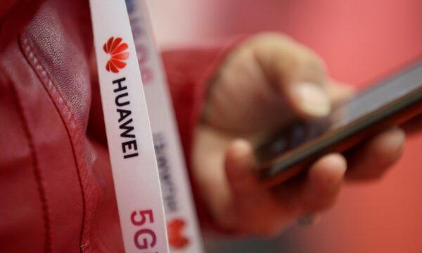 An attendee wears a badge strip with the logo of Huawei and a sign for 5G at the World 5G Exhibition in Beijing, China, on Nov. 22, 2019. (Jason Lee/Reuters)