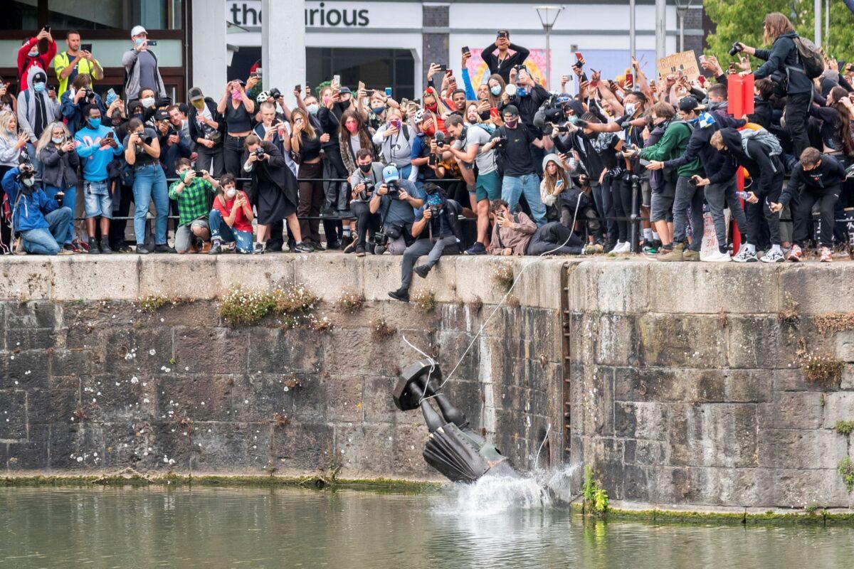 File photo shows the toppled statue of 17th-century merchant Edward Colston as it is tossed into the water during a Black Lives Matter protest in Bristol, England, on June 7, 2020. (Keir Gravil via Reuters)