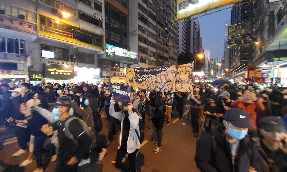 Protesters marching with a hand-painted banner by Otto Yuen, known as The Lennon Wall painter, in Hong Kong. (Courtesy of Otto Yuen)