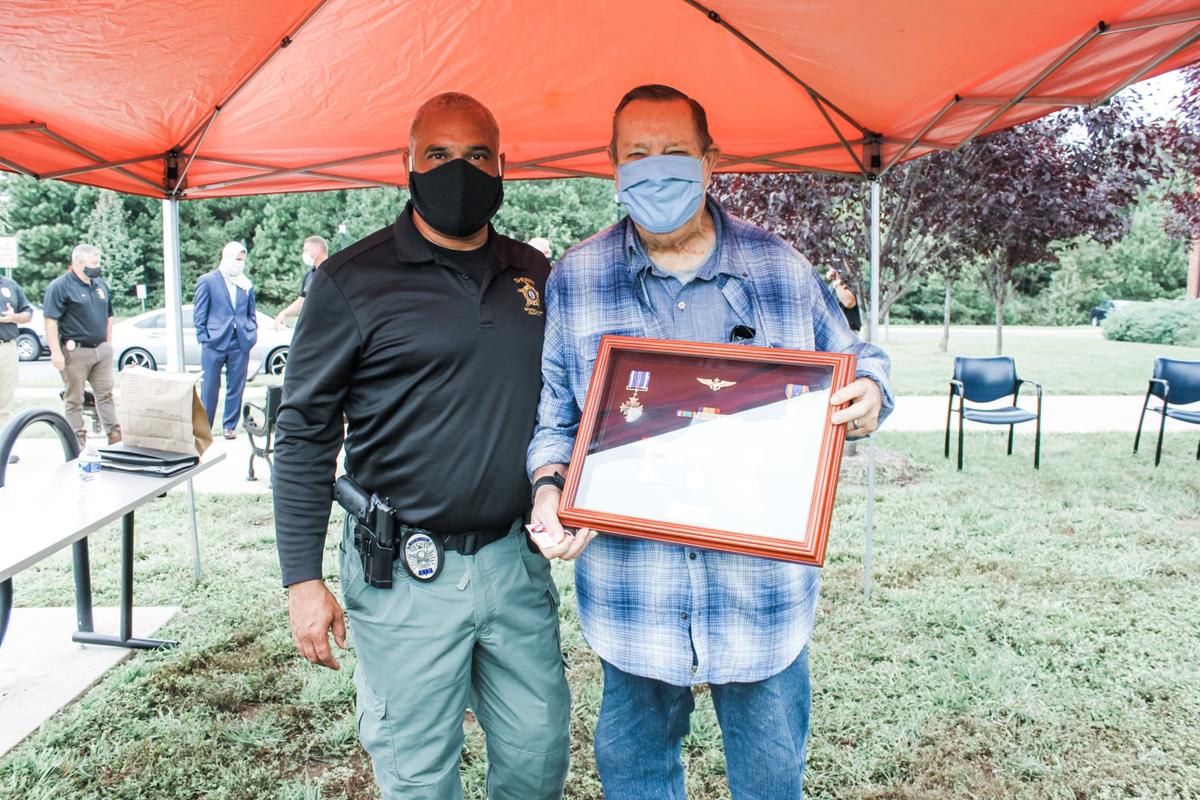 Retired Marine Corps Lt. Col. Thomas Faleskie holds a box containing the medals next to Det. Frank Corona, who helped organize the plan to replace them. (Courtesy of Spotsylvania Sheriff's Office)