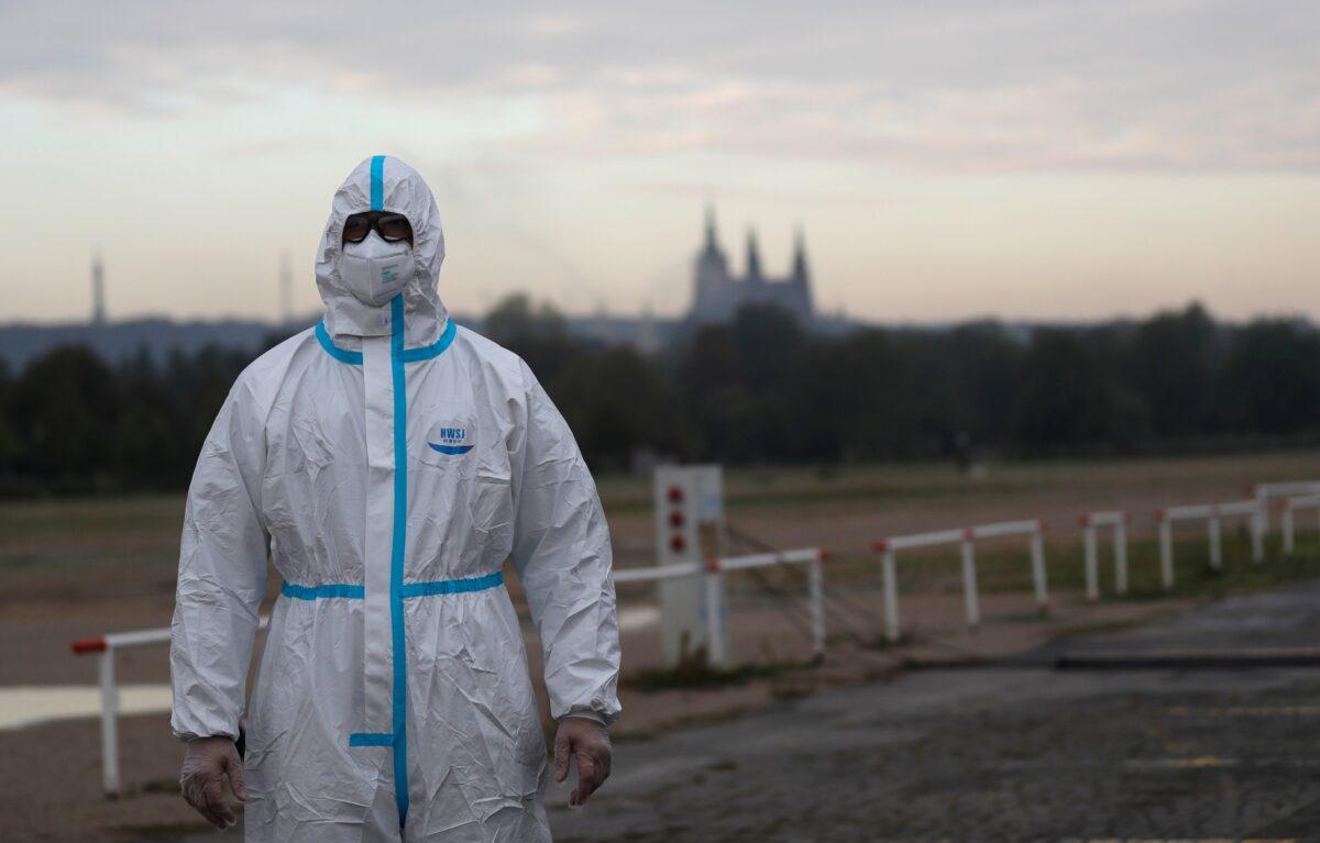 An election committee member wearing a protective suit, waits for voters to arrive for regional and senate elections at a drive-in polling station in Prague, Czech Republic, on Sept. 30, 2020. (Petr David Josek/AP Photo)