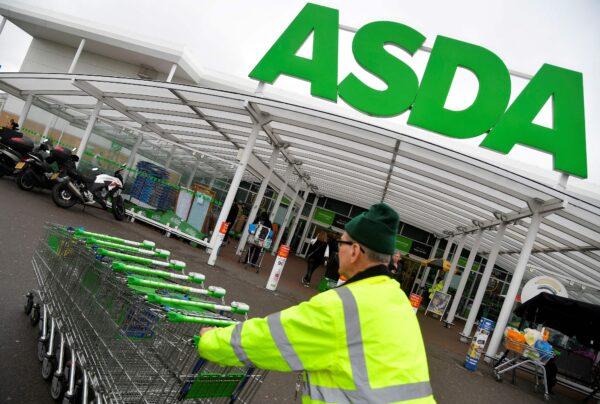 A worker pushes shopping trolleys at an Asda store in West London on April 28, 2018. (Toby Melville/Reuters)