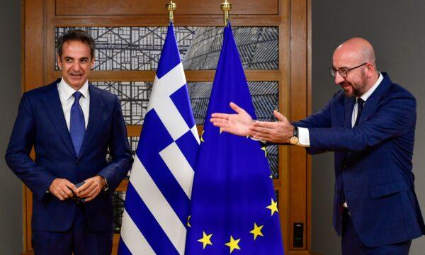 European Council President Charles Michel, right, greets Greek Prime Minister Kyriakos Mitsotakis ahead of a meeting on the sidelines of an EU summit in Brussels, on Oct. 1, 2020. (John Thys/Pool via AP)
