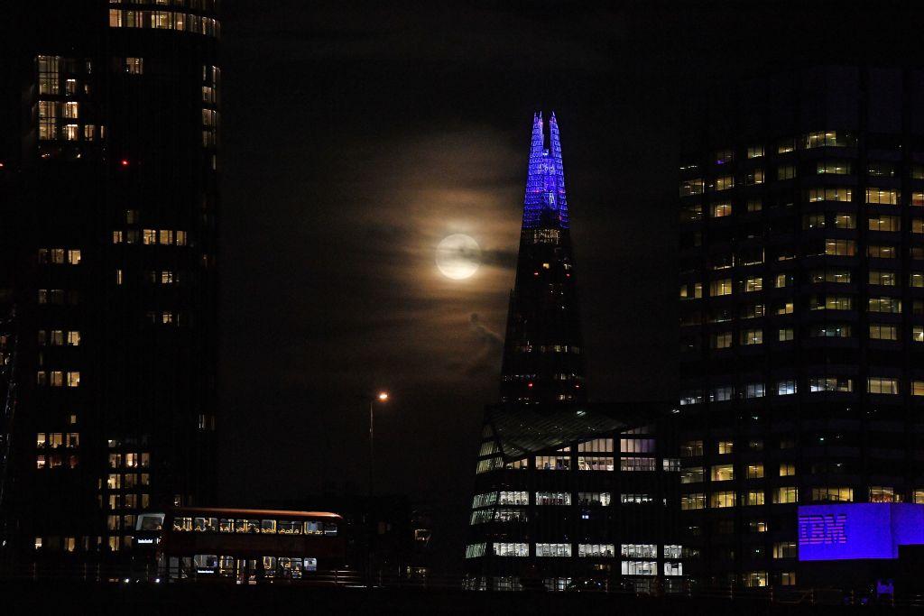 A full moon rises beyond The Shard in central London on Oct. 1, 2020. (JUSTIN TALLIS/AFP via Getty Images)