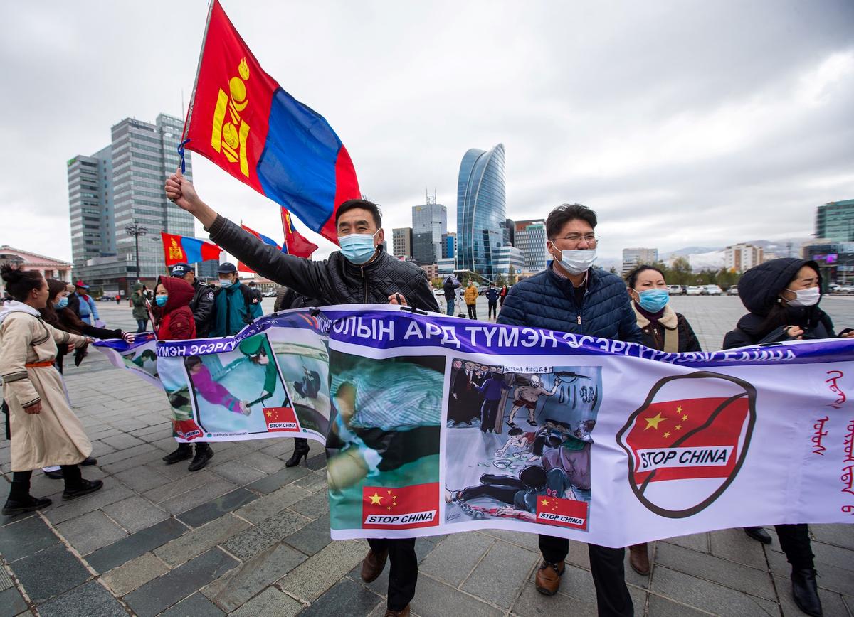 Protestors hold banners and wave the Mongolian flag during a protest in Ulaanbaatar, the capital of Mongolia, against Chinese policies in the neighboring Inner Mongolia Autonomous Region in China, on Oct. 1, 2020. (Byambasuren Byamba-Ochir/AFP via Getty Images)