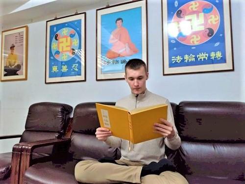 Fabian reading <em>Zhuan Falun</em>, the main text of Falun Gong. (<a href="https://en.minghui.org/html/articles/2020/2/27/183419.html">Minghui</a>)