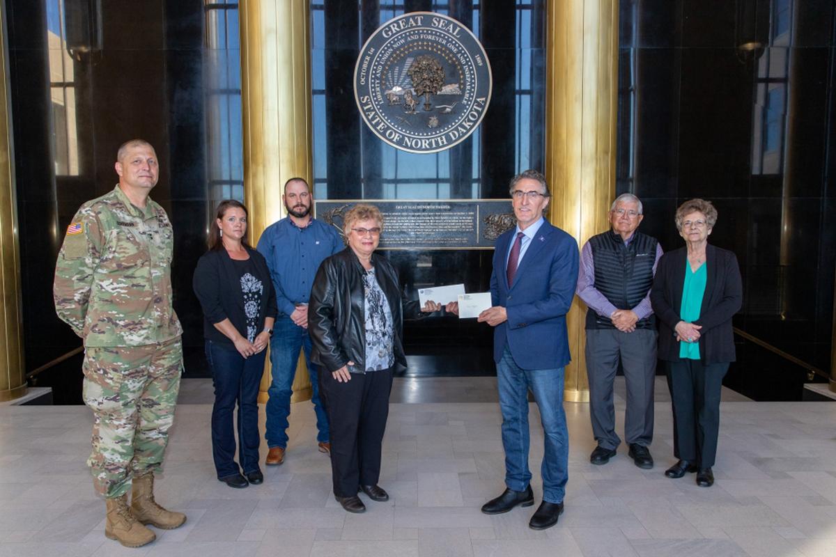 Gov. Doug Burgum presents Ronald Hepper's dog tag to his wife, Ruth. (Courtesy of North Dakota Office of the Governor)