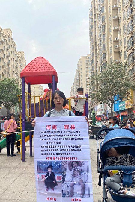 He Fangmei is holding a banner to raise awareness about her child's health conditions after being injected with a faulty vaccine. (Supplied)