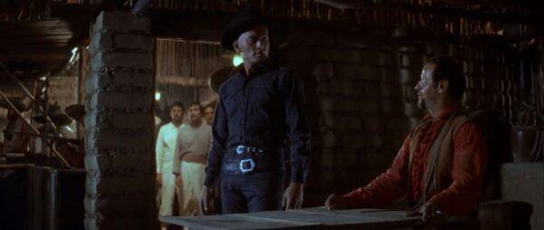 Chris Adams (Yul Brynner, L) must give in to the villain Calvera (Eli Wallach), at least for the moment. (United Artists)