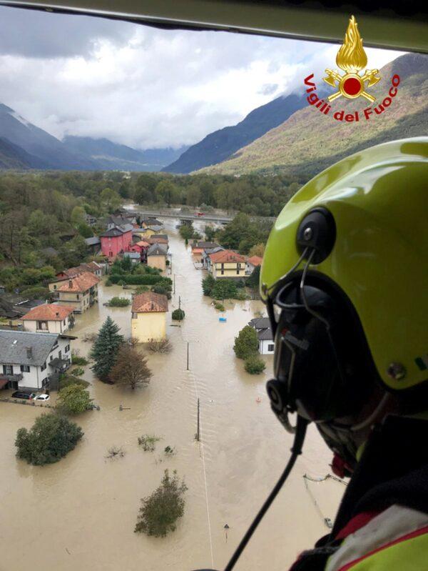 In this image made available on Oct. 4, 2020, firefighters fly over flooding in the town of Ornavasso, in the northern Italian region of Piedmont. (Firefighter Vigili del Fuoco via AP)