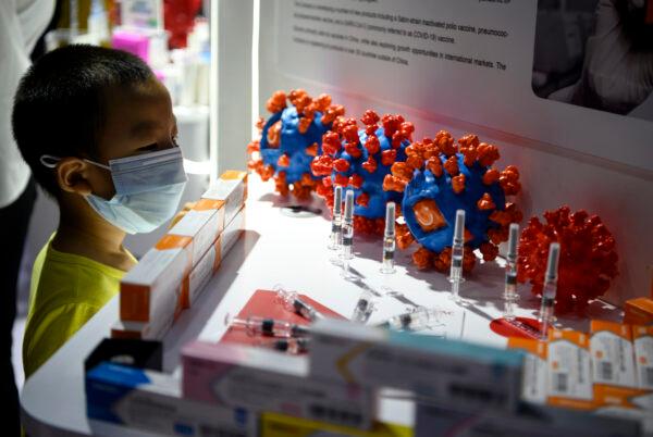 A boy looks at Sinovac Biotech's vaccine candidate for COVID-19 on display at the China International Fair for Trade in Services in Beijing, China on Sept. 6, 2020. (NOEL CELIS/AFP via Getty Images)