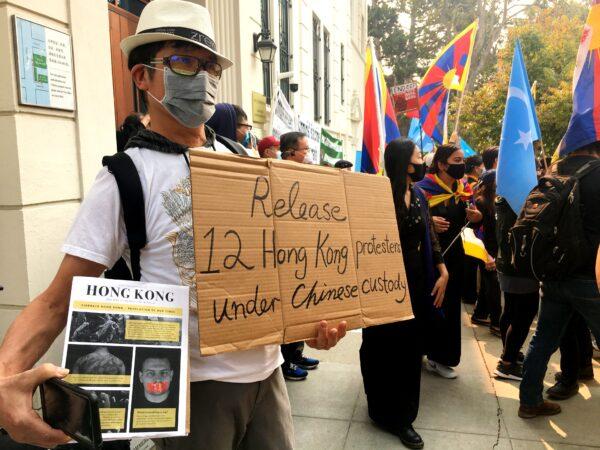 A Hongkonger holds a sign at the San Francisco Chinese Consulate on China’s National Day on Oct. 1, 2020. (Ilene Eng/The Epoch Times)