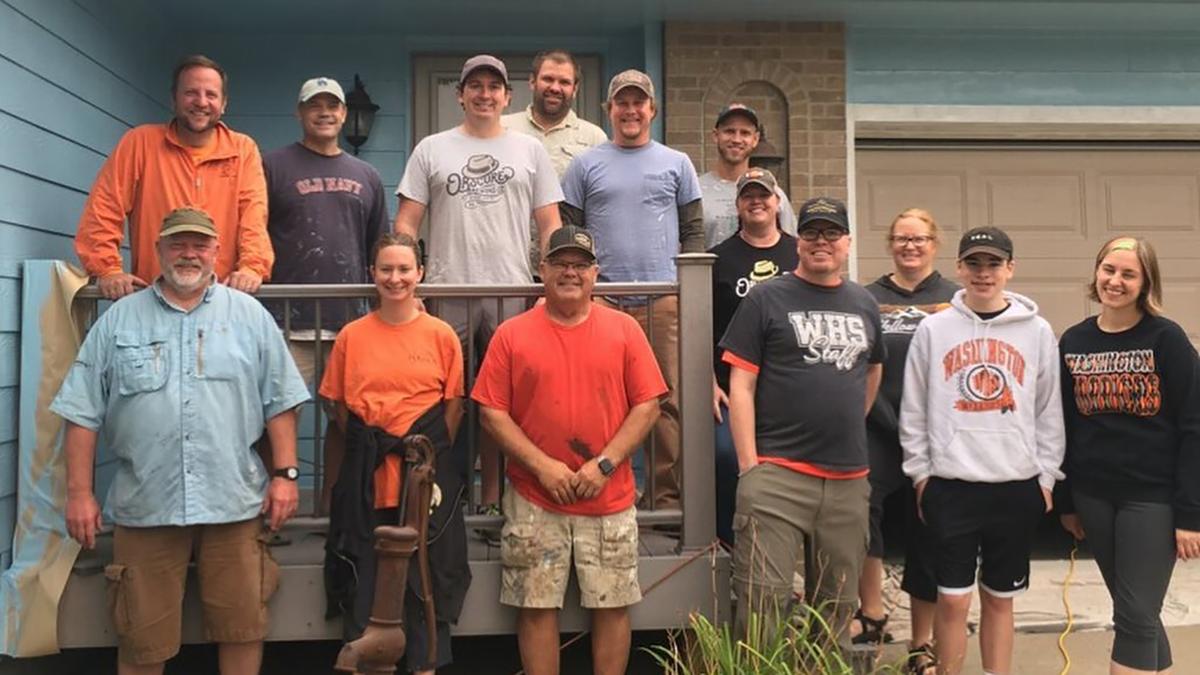 Tim Gjoraas, wearing a black shirt in the front row, stands with the group of volunteers in front of his newly painted house. (Courtesy of Tim Gjoraas)