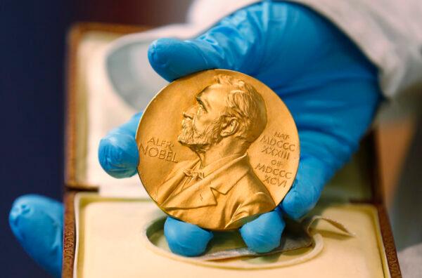 A national library employee shows a gold Nobel Prize medal in Bogota, Colombia, on April 17, 2015. (Fernando Vergara/ File/AP Photo)